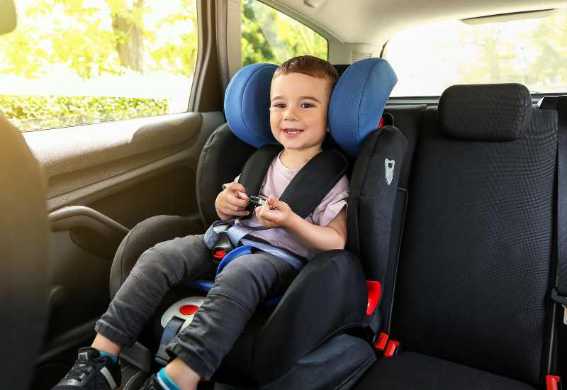 Enfant installé dans un siège auto pour un trajet en famille