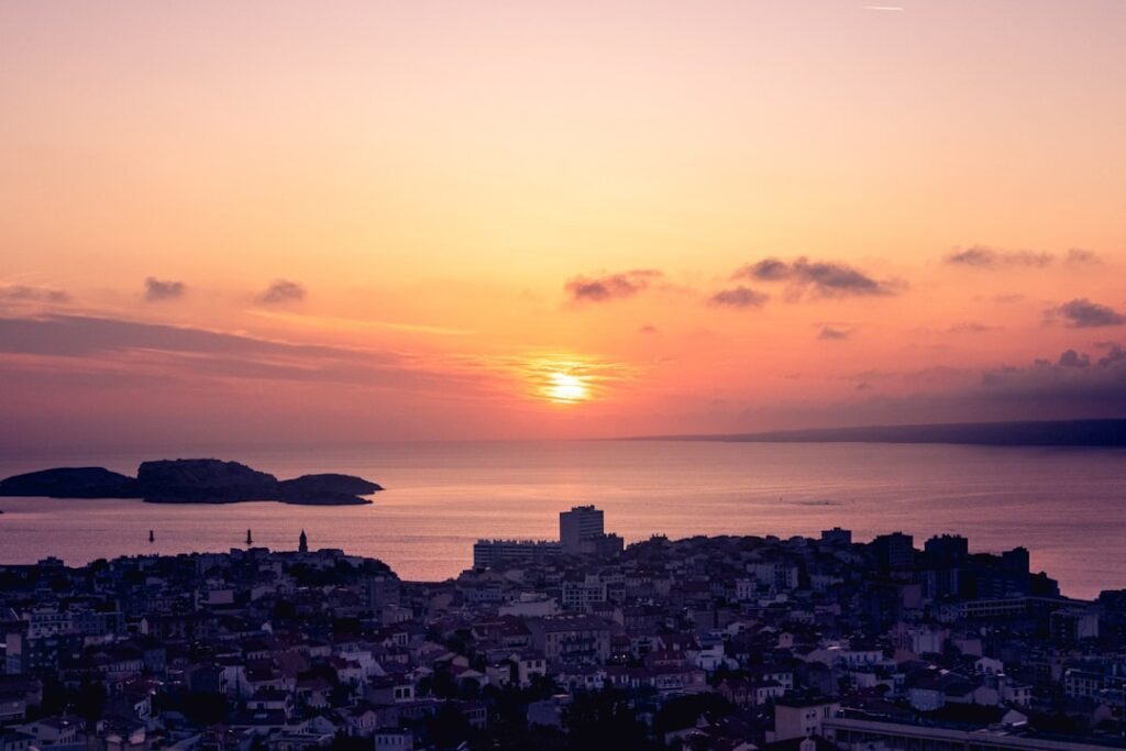 Sunset over a coastal city with islands.