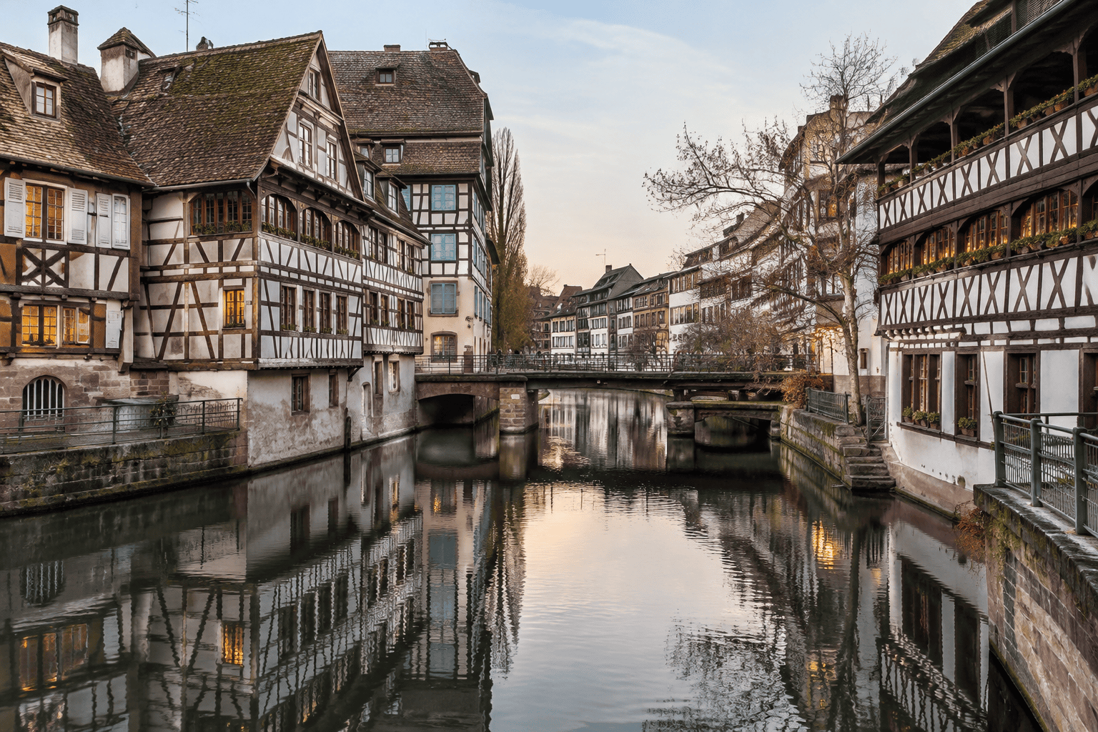 Maisons à colombages bordant un canal, avec leurs façades et leurs reflets dans l’eau.