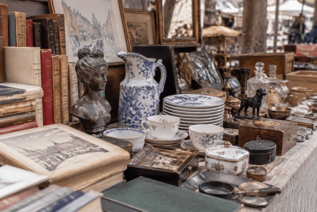 Livres, vaisselle à motifs bleus, bibelots et petits objets anciens disposés sur une table.