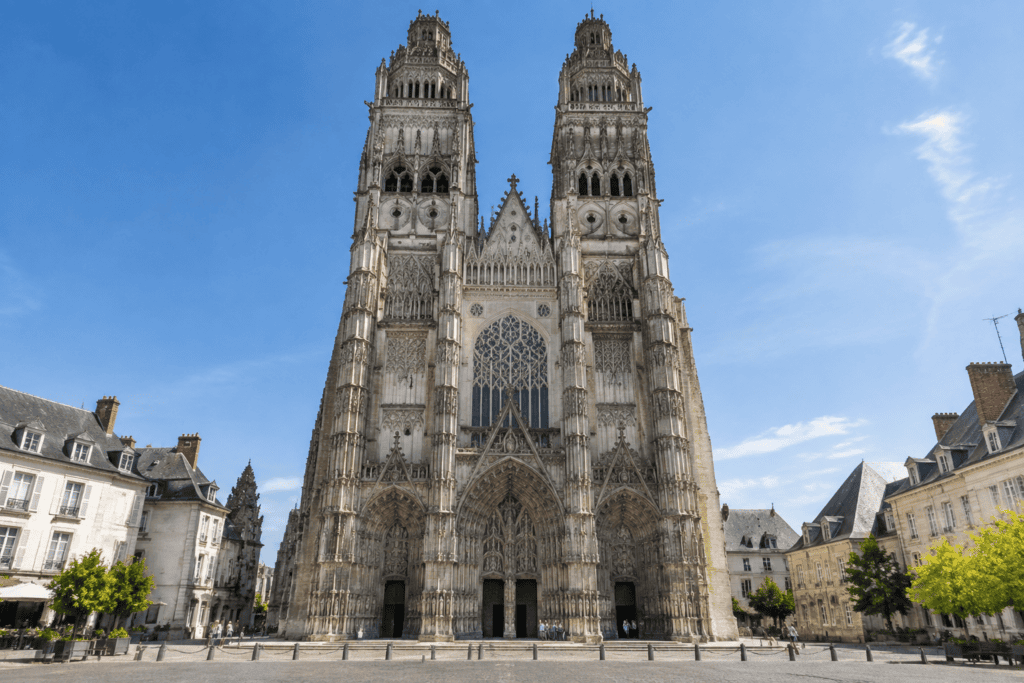 Façade gothique de la cathédrale Saint-Gatien, avec deux hautes tours, un grand vitrail et des portails sculptés.