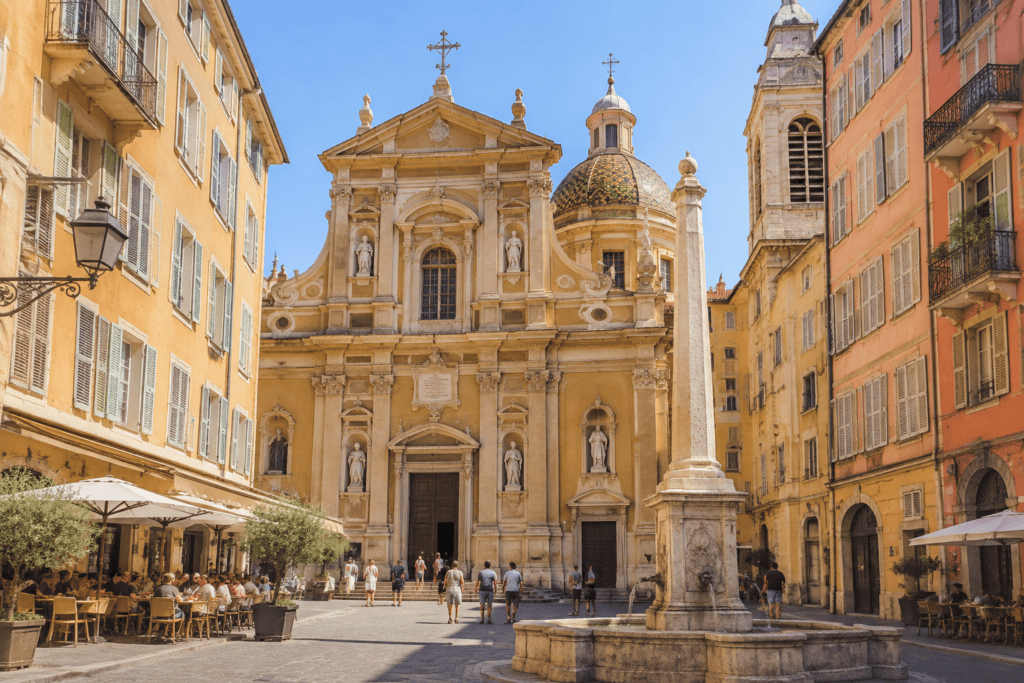 Façade baroque de la cathédrale Sainte-Réparate et son dôme carrelé, au fond de la place Rossetti bordée de façades colorées.
