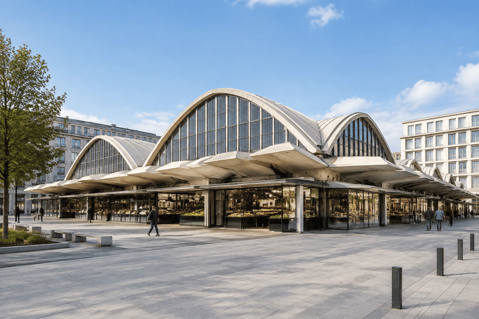 Les Halles centrales du Havre vues depuis la place, avec leurs voûtes vitrées, leurs auvents et les boutiques en façade.