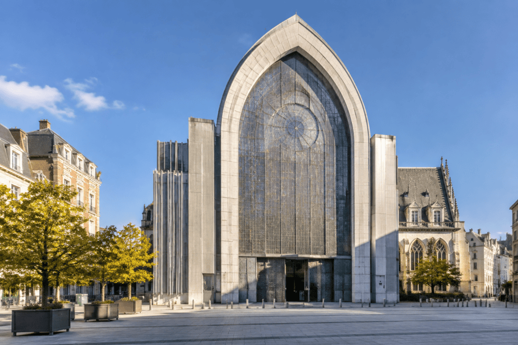 La façade de la cathédrale Notre-Dame-de-la-Treille à Lille, dominée par un grand arc de pierre claire et un panneau central translucide.
