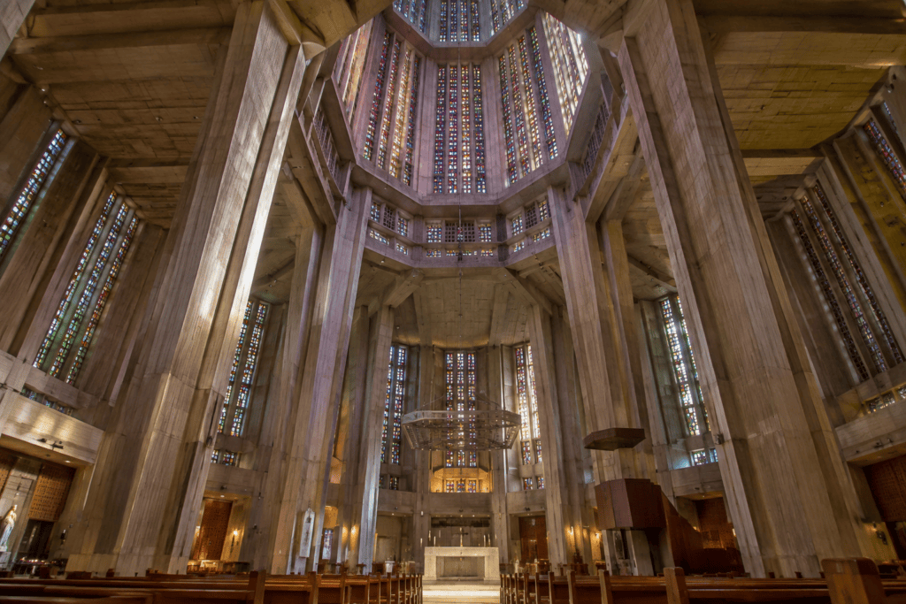 Vue depuis la nef vers la tour-lanterne octogonale et les vitraux colorés de l’église Saint-Joseph.