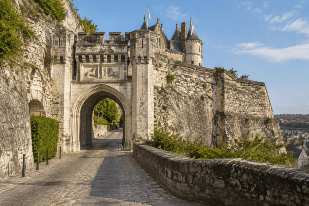 Une porte voûtée s’ouvre dans les remparts de pierre du château d’Amboise, au bout d’un chemin pavé.