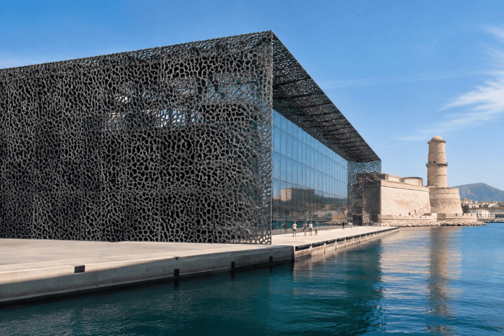 Le bâtiment J4 du Mucem, avec sa façade sombre ajourée et ses baies vitrées, longe le front de mer.