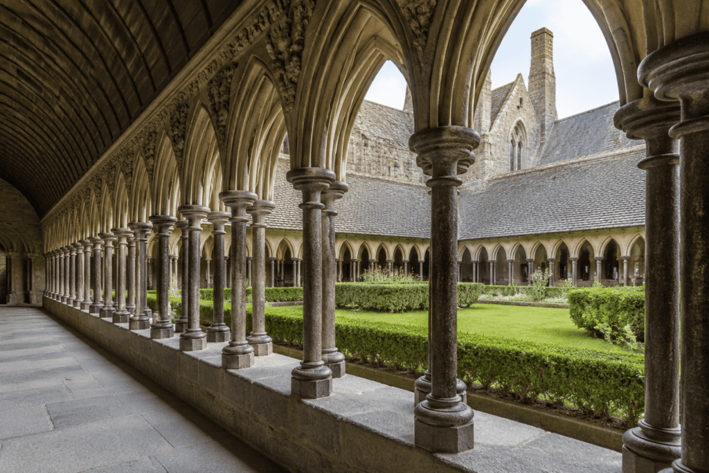 Arcades de pierre entourant le jardin intérieur du cloître de l’abbaye.