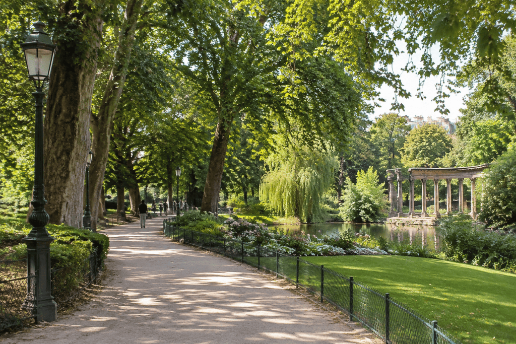 Allée et colonnade du parc Monceau à Paris Allée ombragée bordée d’arbres dans un parc, avec un bassin et une colonnade à droite.