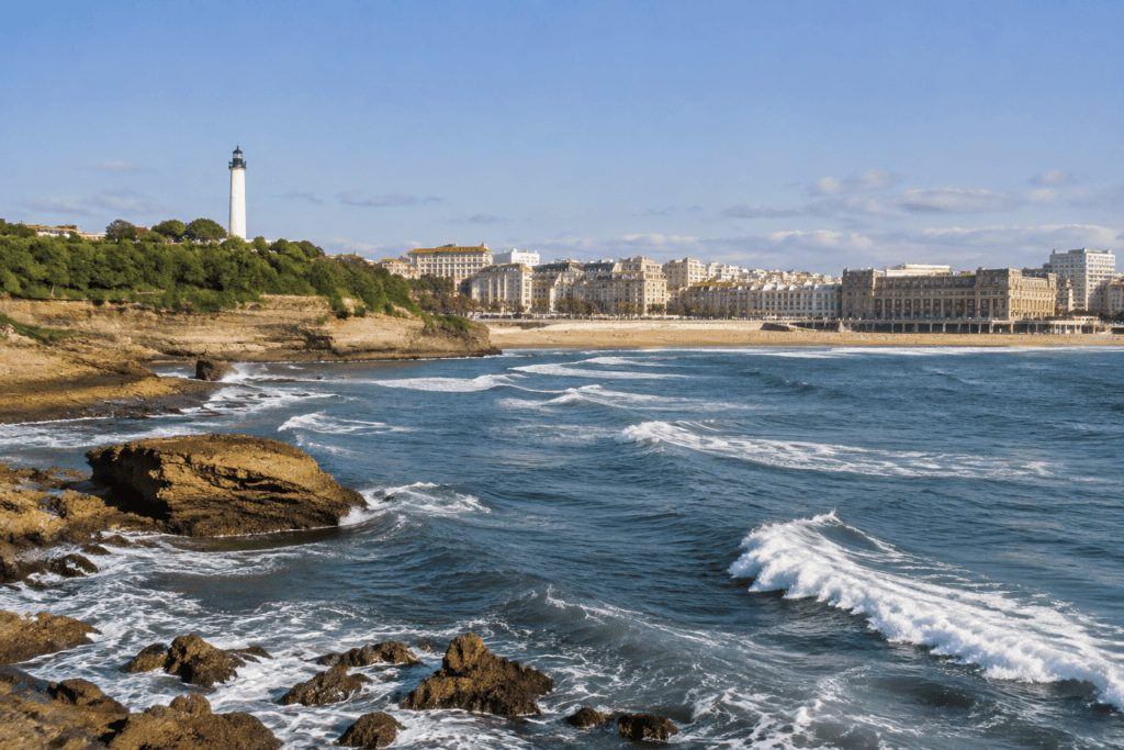 Le phare se dresse au-dessus d’une côte rocheuse, face aux vagues et aux bâtiments de la Grande Plage de Biarritz.