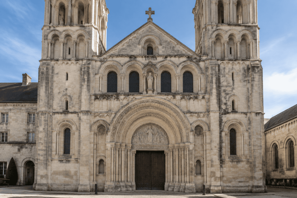 Façade occidentale de l’église de la Trinité, avec son portail sculpté en plein cintre et ses deux tours.