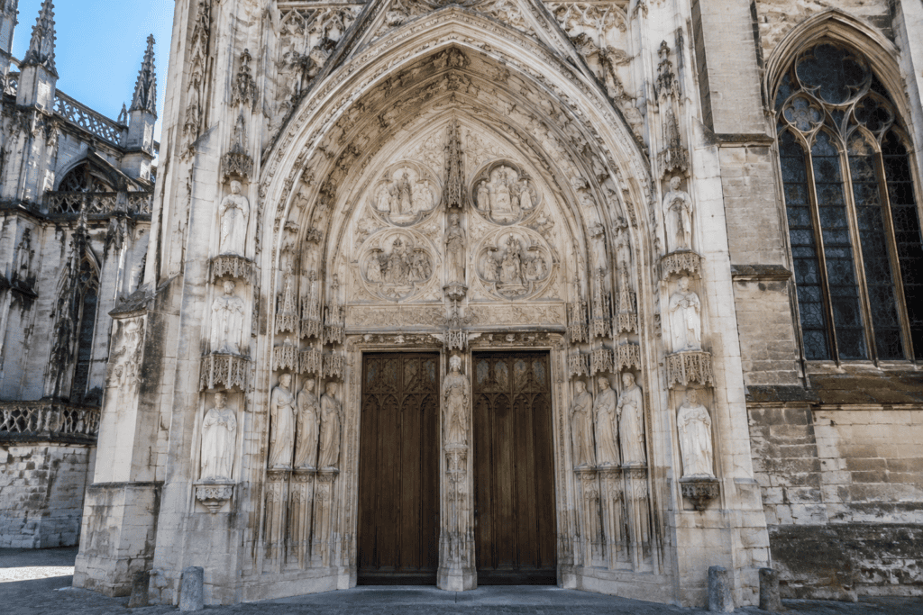 Portail gothique à deux portes, orné de figures sculptées et de médaillons en quadrilobes, sur la cathédrale Notre-Dame de Rouen.