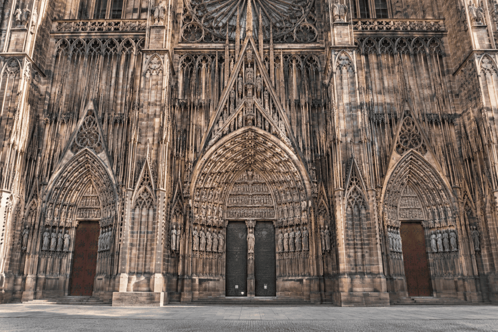 Les trois portails gothiques sculptés de la façade occidentale de la cathédrale Notre-Dame de Strasbourg, avec leurs archivoltes et leurs statues.