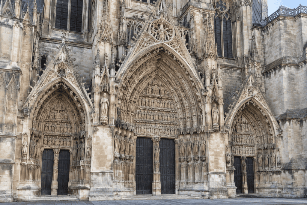 Trois portails gothiques richement sculptés, celui du centre étant plus grand, sur la cathédrale de Reims.