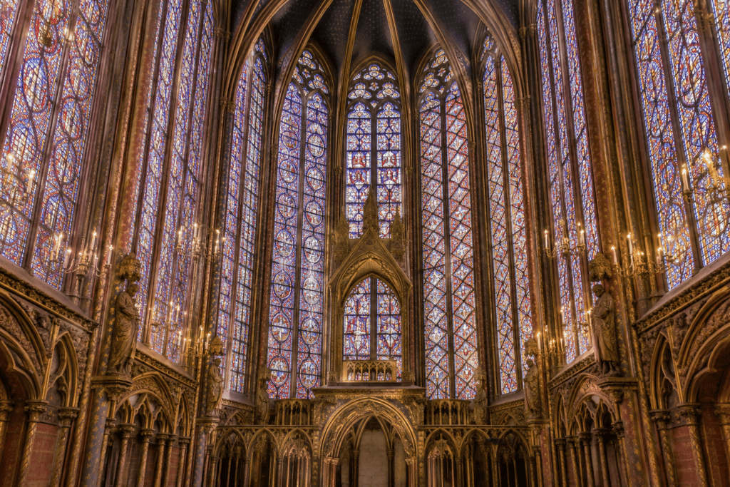 De hautes verrières colorées s’élèvent au-dessus des arcs gothiques de la chapelle.