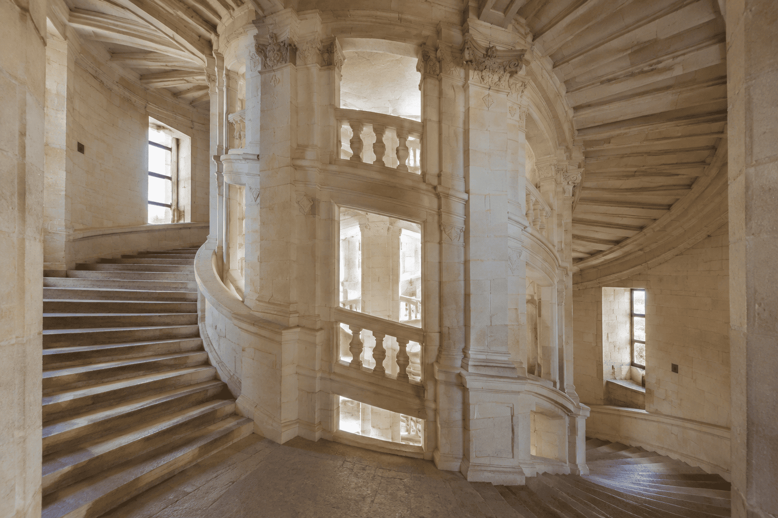 Escalier de pierre aux volées courbes autour d’un noyau central ajouré, à l’intérieur du château de Chambord.