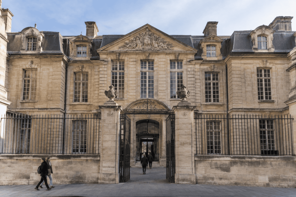 Façade en pierre de l’hôtel Salé, avec un portail central, une grille et des fenêtres à meneaux.