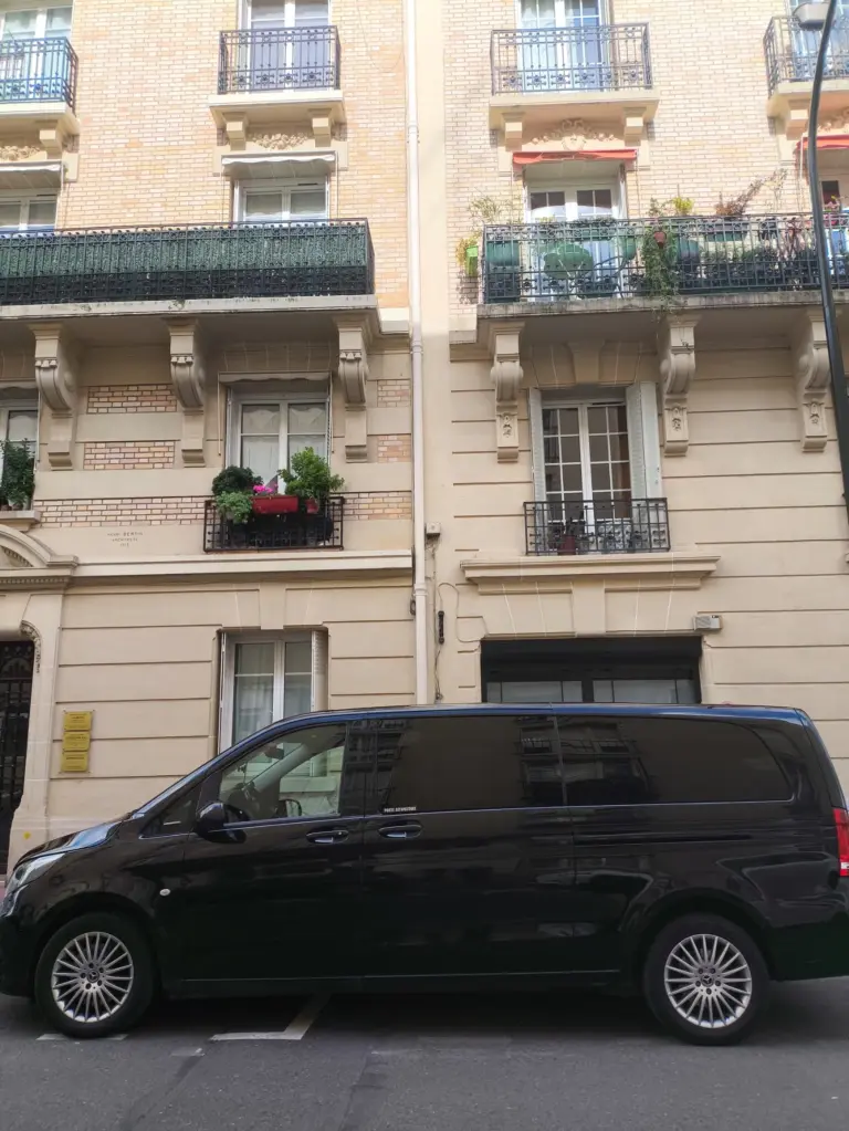Van Mercedes noir devant un immeuble parisien