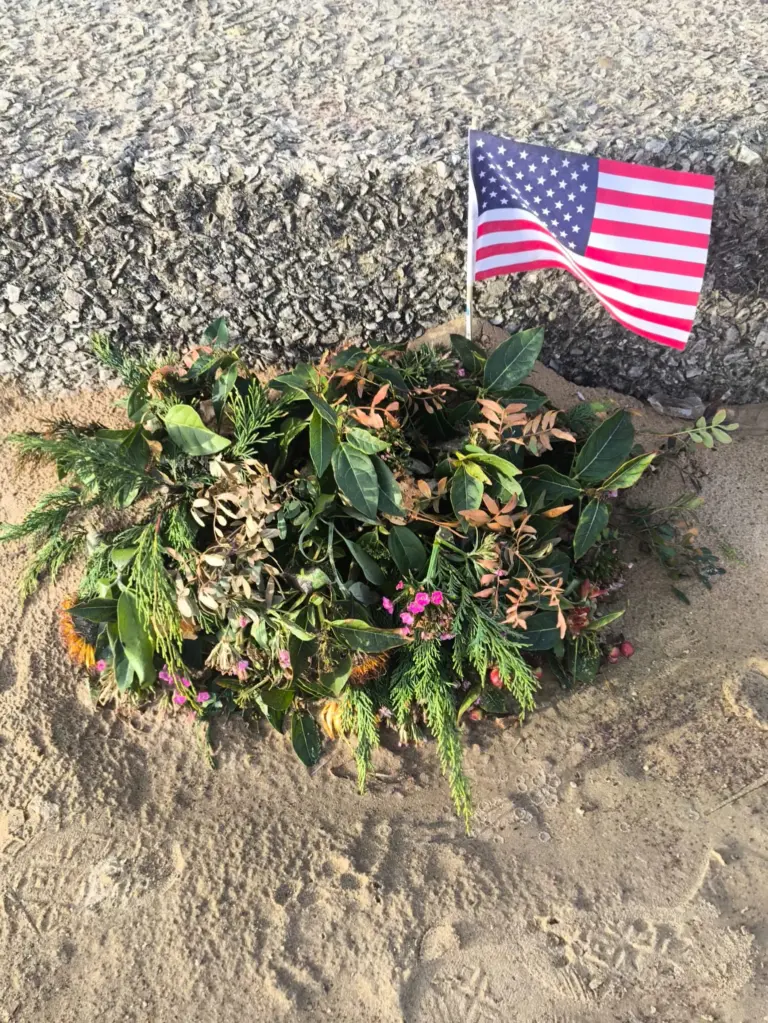 Couronne de fleurs et drapeau américain sur un lieu de mémoire