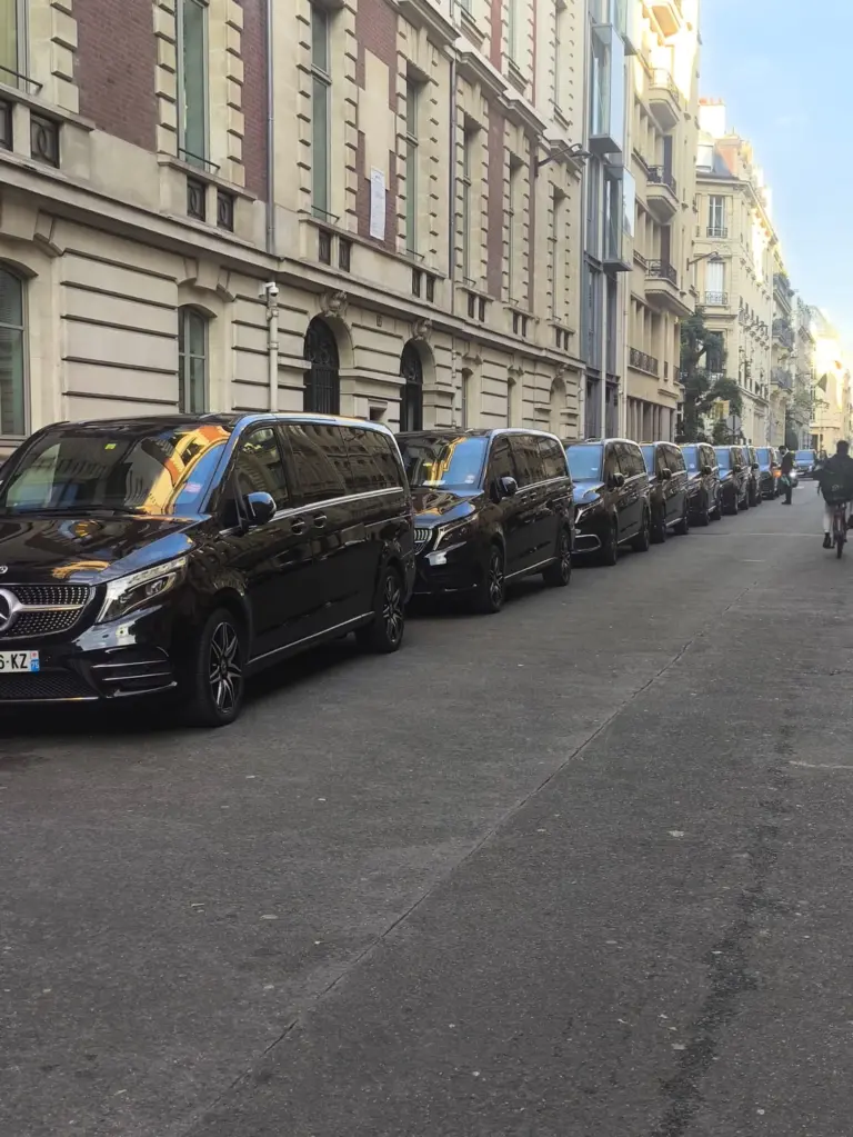 File de vans Mercedes noirs dans une rue parisienne