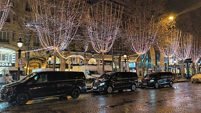 Vans noirs alignés le long d’une avenue illuminée