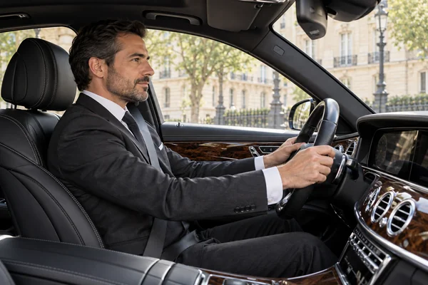 Un chauffeur au poste de conduite d’une berline